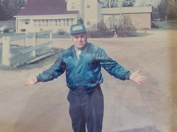 Old photo of Joe Bollig with arms stretched out showing off his property